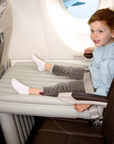 Child sitting on Flyaway Kids Bed inflatable airplane bed